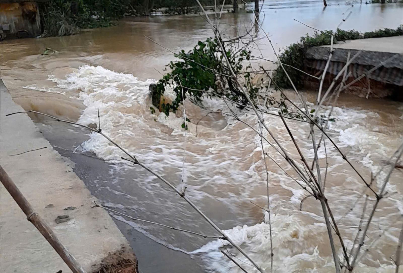 Hiện trường đoạn đê kết hợp đường giao thông bị lũ cuốn trôi.