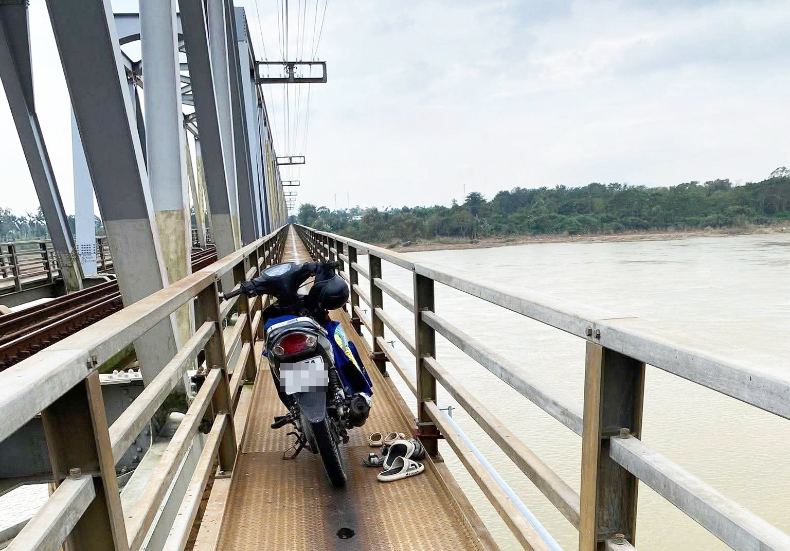 Tin để xe máy, dép và ba lô trên cầu Trường Xuân rồi ôm 2 con nhảy xuống sông.