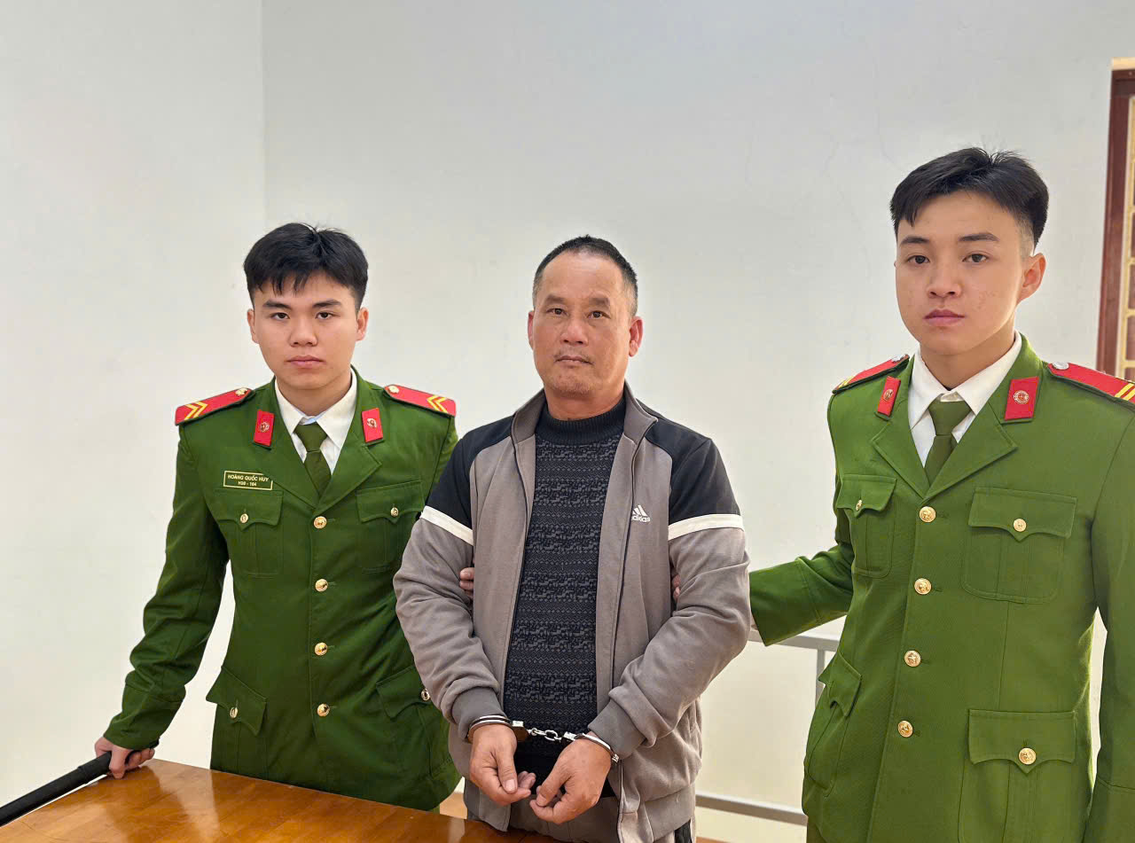 Đối tượng Đoàn Văn Sáng (áo xám) tại Cơ quan Công an.