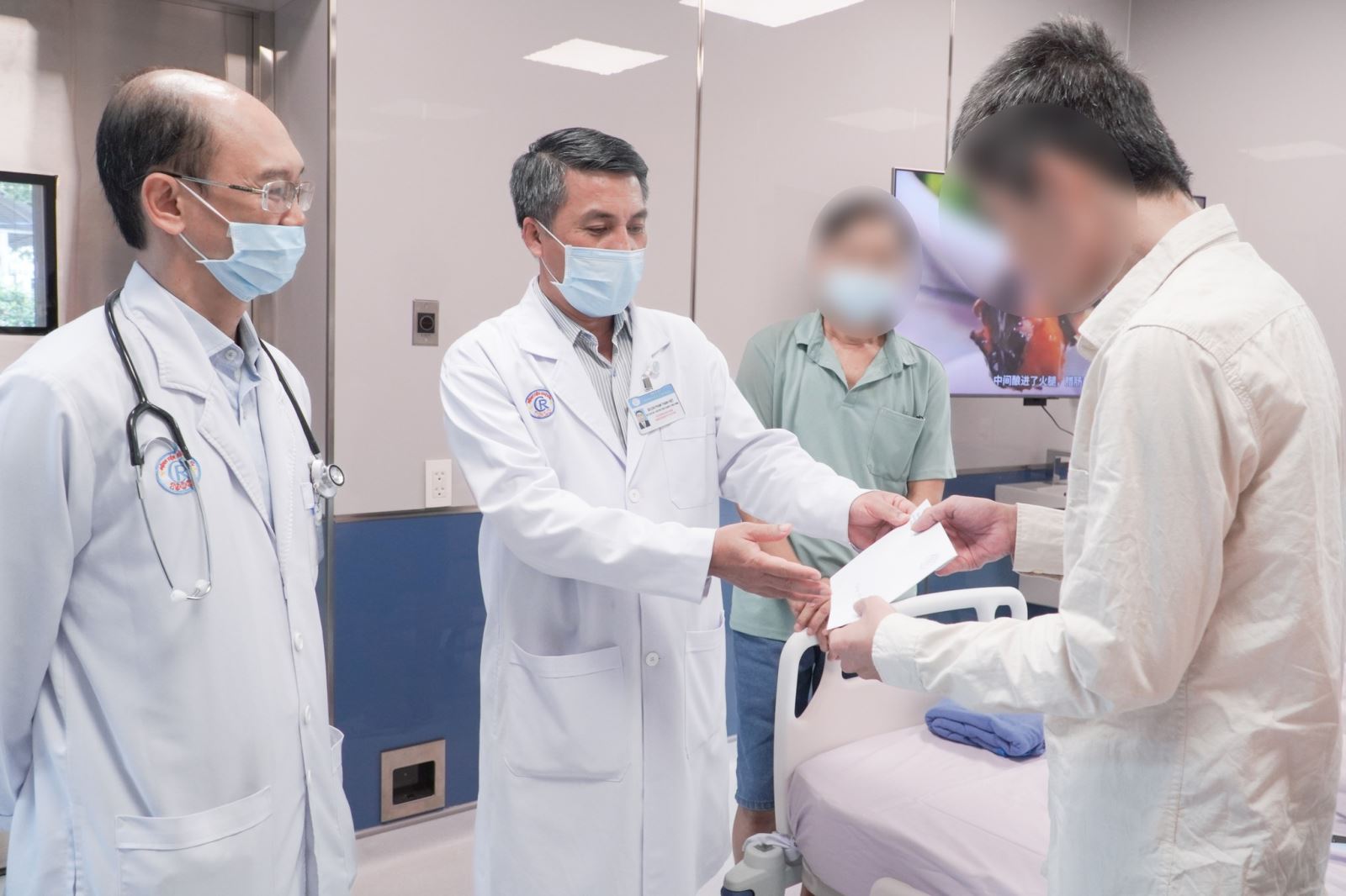 BS.CKII Phạm Thanh Việt - Phó Giám đốc phụ trách Quản lý điều hành Bệnh viện Chợ Rẫy trao giấy xuất viện cho bệnh nhân.